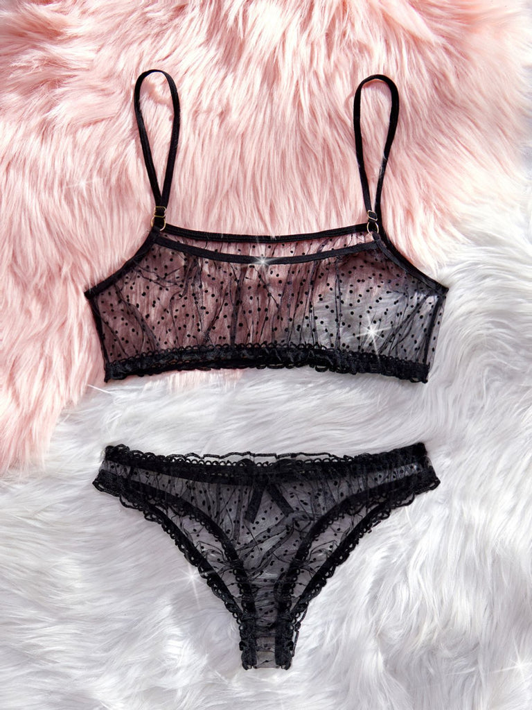 Black lace lingerie set on a fluffy pink and white surface