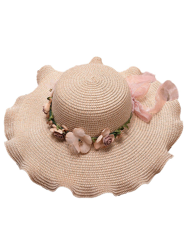 Beige straw hat with floral decorations on a white background