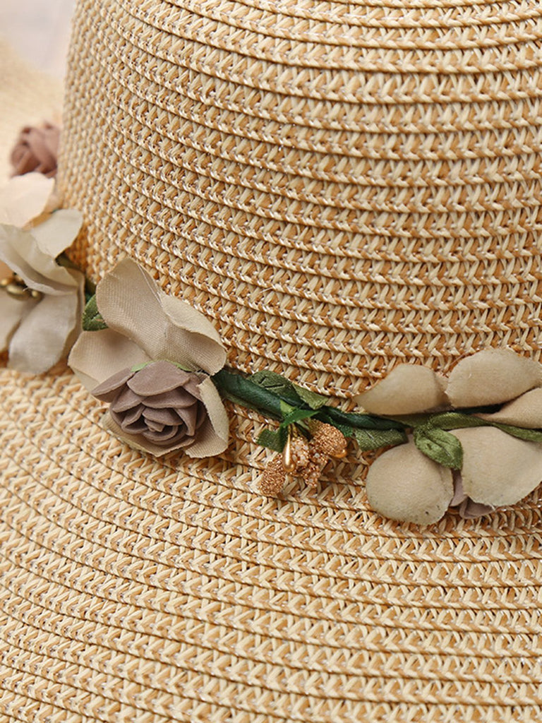 Beige straw hat with floral decorations on a blurred background