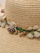 Beige straw hat with floral decorations on a blurred background