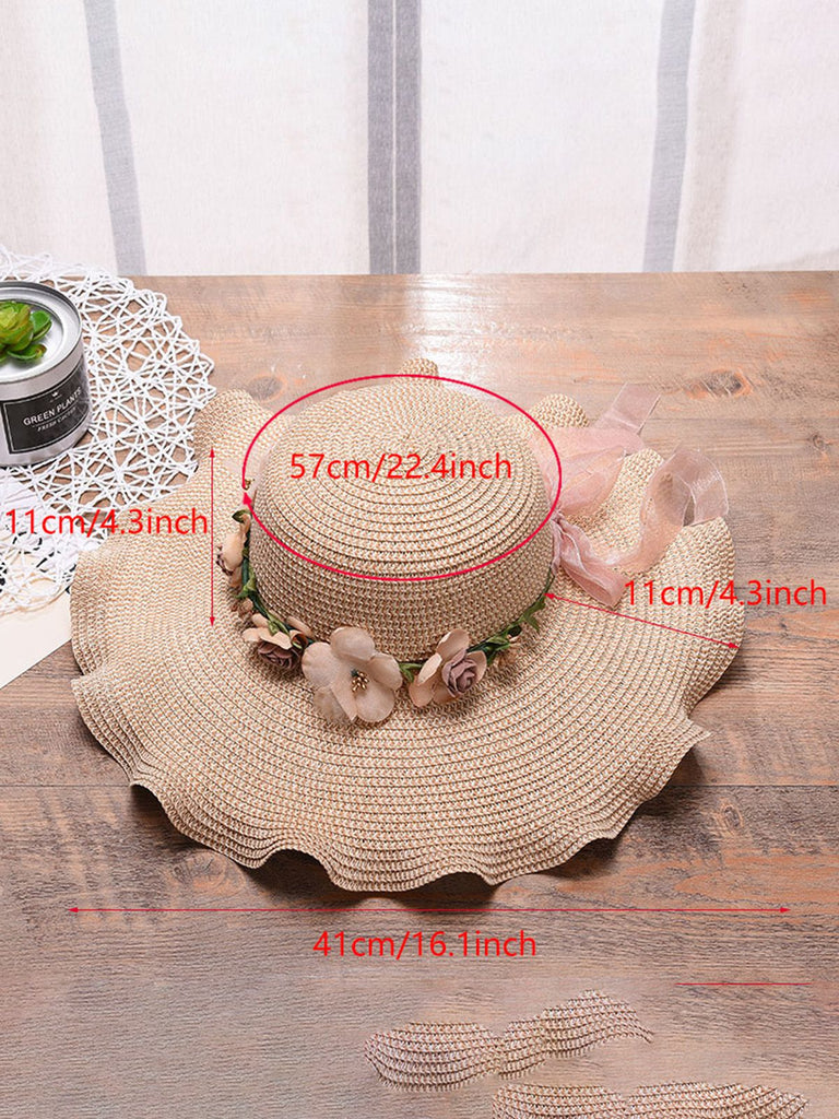 Beige straw hat with floral decorations on a wooden surface, with measurements indicated.
