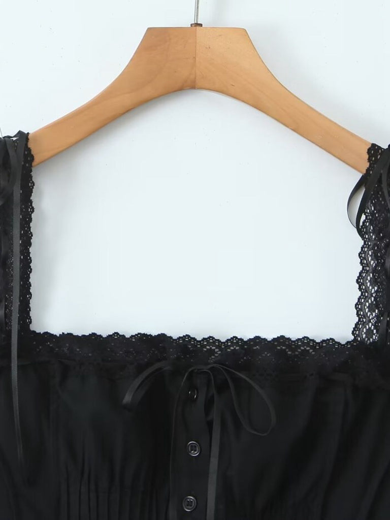 Black lace-trimmed top on a wooden hanger against a white background
