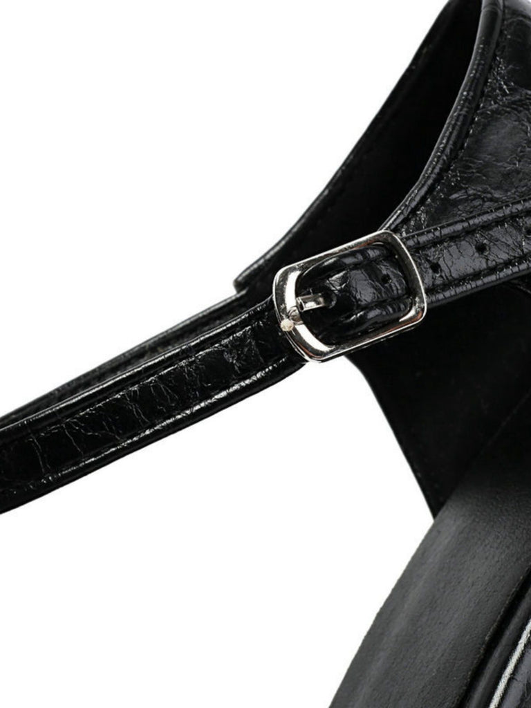 Close-up of a black leather strap with a silver buckle on a white background