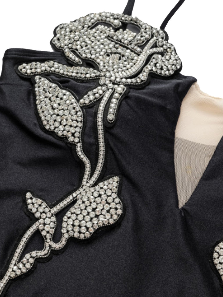 Black swimsuit with a detailed rose design made of crystals on a white background