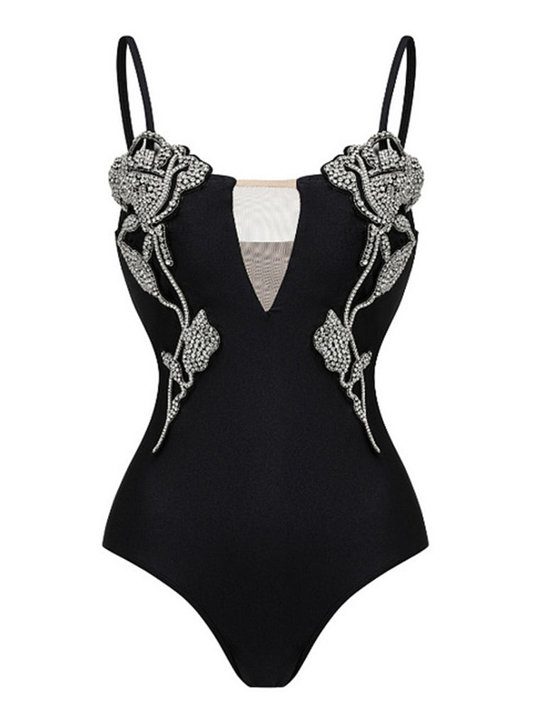 Black swimsuit with floral embellishments on a white background