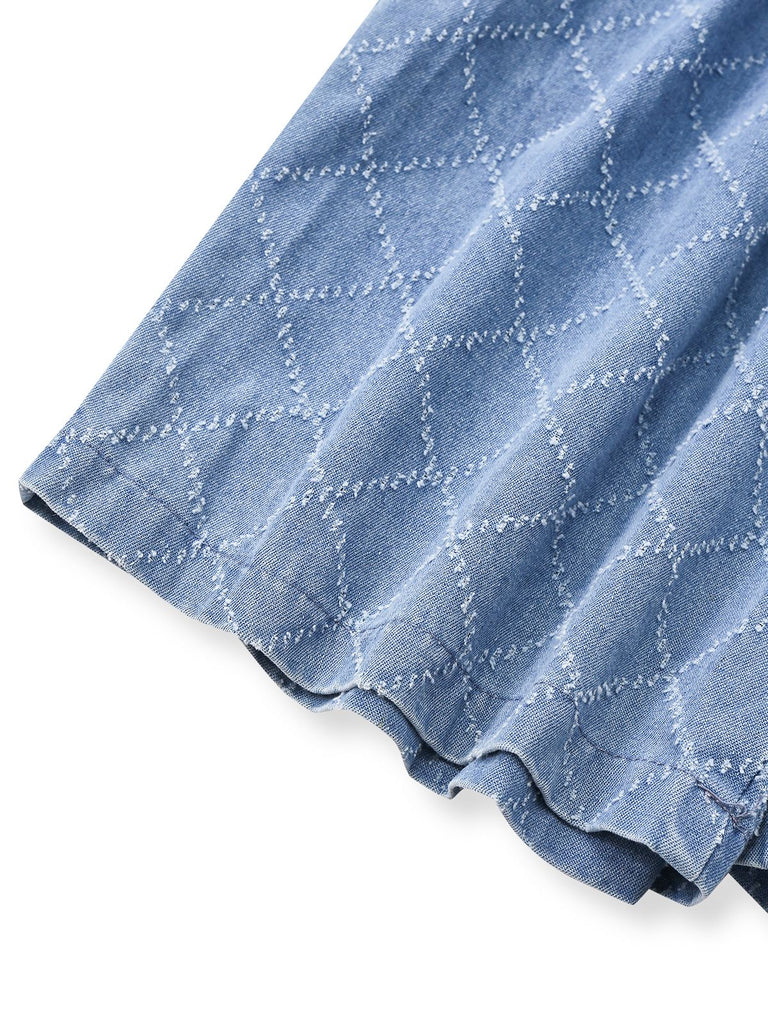 Close-up of a blue denim fabric with white stitching on a white background