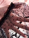 Hand wearing a black polka dot sleepwear on a pink background