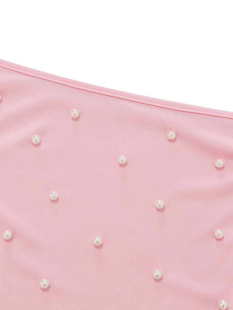 Pink fabric with scattered pearls on a white background