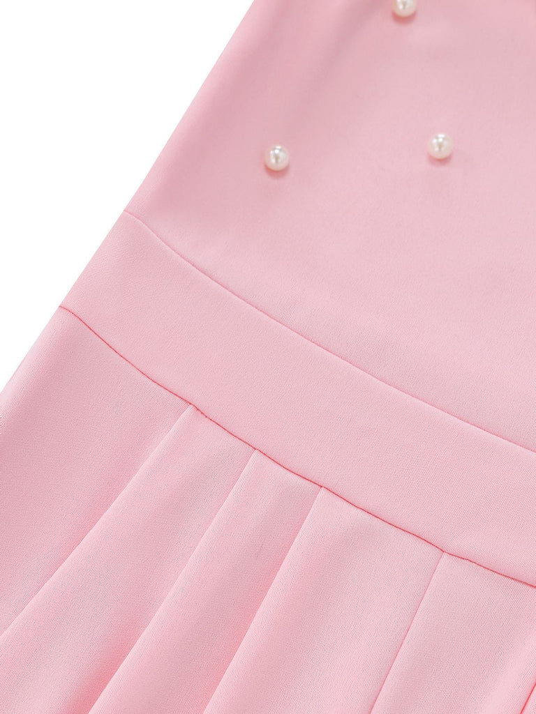 Close-up of a pink jumpsuit with pearl embellishments on a white background