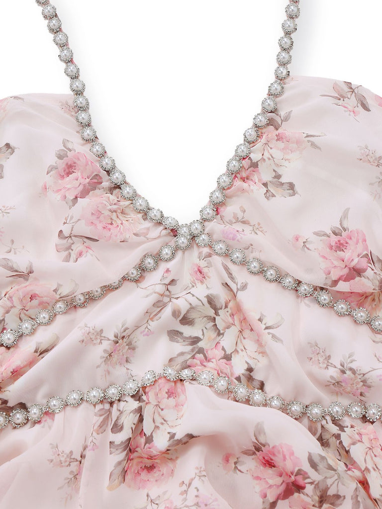 Close-up of a pink floral dress with a beaded neckline on a white background