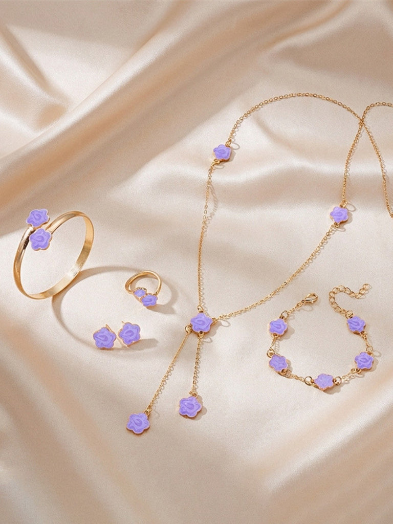 Purple jewelry set with purple stones on a beige fabric background