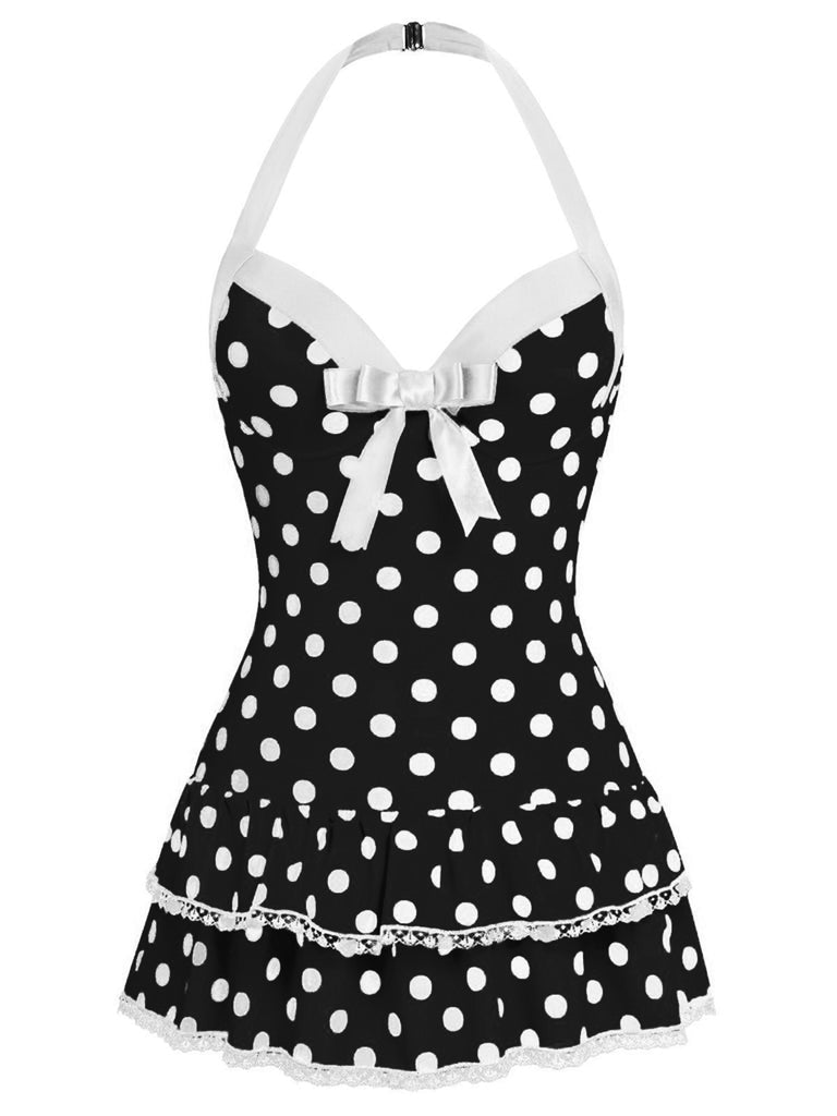 Vintage-inspired black and white polka dot one-piece swimsuit with a halter neck and white bow detail.