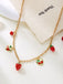 Gold necklace with strawberry-shaped pendants on a white background