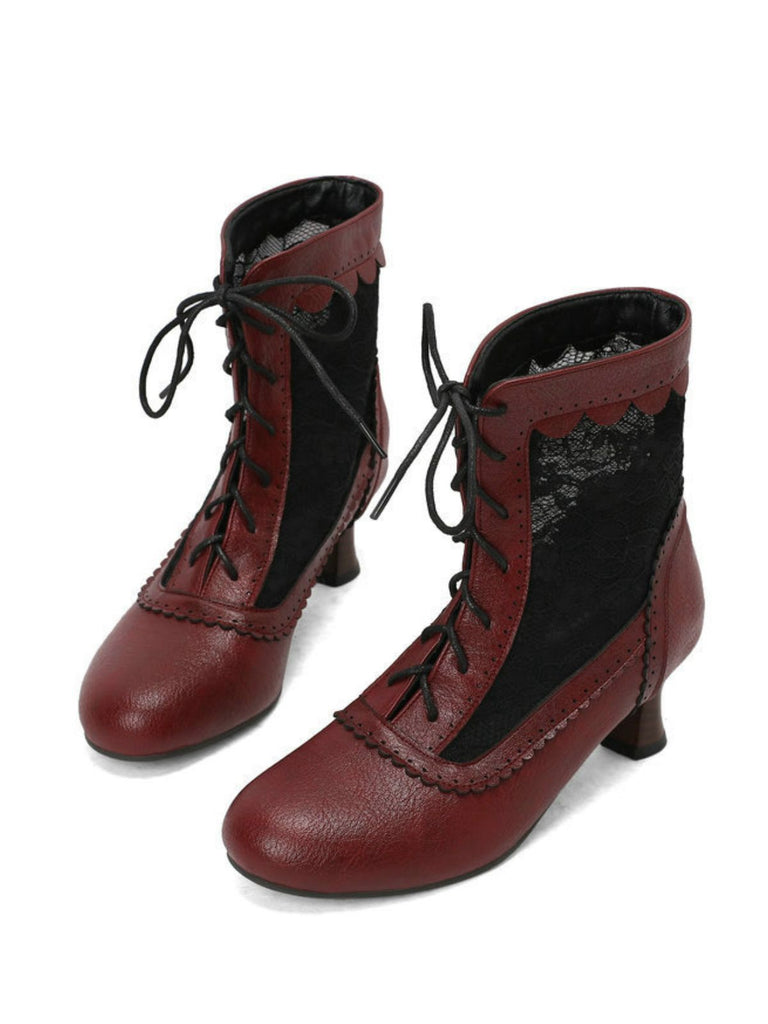 Pair of red ankle boots with black laces on a white background