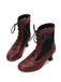 Pair of red ankle boots with black laces on a white background