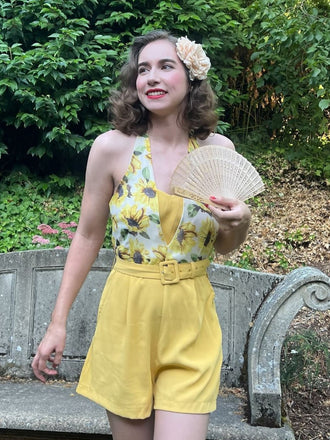 She finds her 1950s story in this Yellow 1950s Sunflower Halter Romper