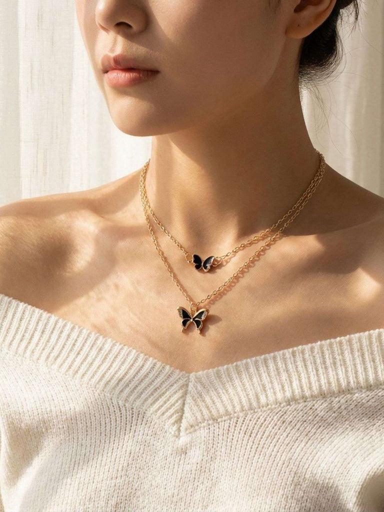 Close-up of a person wearing a butterfly-themed necklace with a soft background