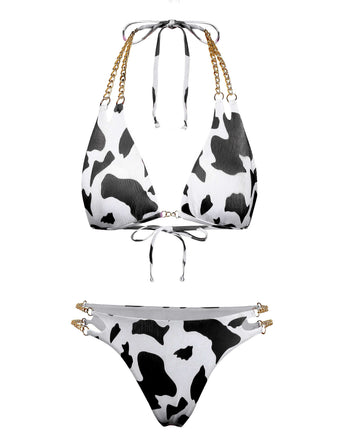 A triangle bikini set featuring a black and white cow print with decorative gold chain-link straps on both the top and high-cut bottoms.