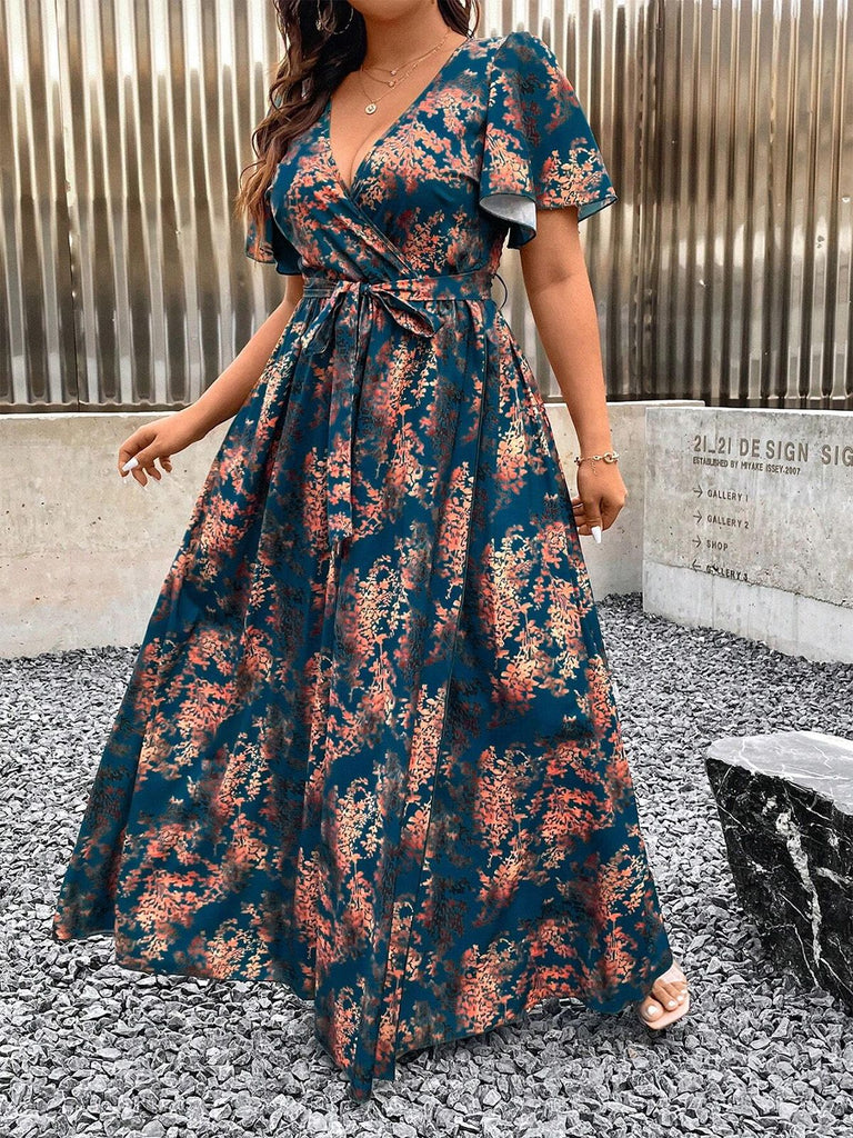 Full-length outdoor view of the teal and rust floral wrap dress highlighting the flowy skirt and waist tie.