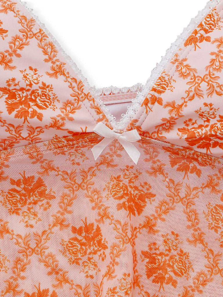 Close-up of a pink lace garment with orange floral patterns and a white bow.
