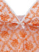 Close-up of a pink lace garment with orange floral patterns and a white bow.