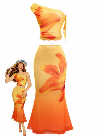 A vibrant two-piece set featuring an orange and yellow gradient with a large lily floral print, including a one-shoulder cropped top and a matching mermaid-style maxi skirt.