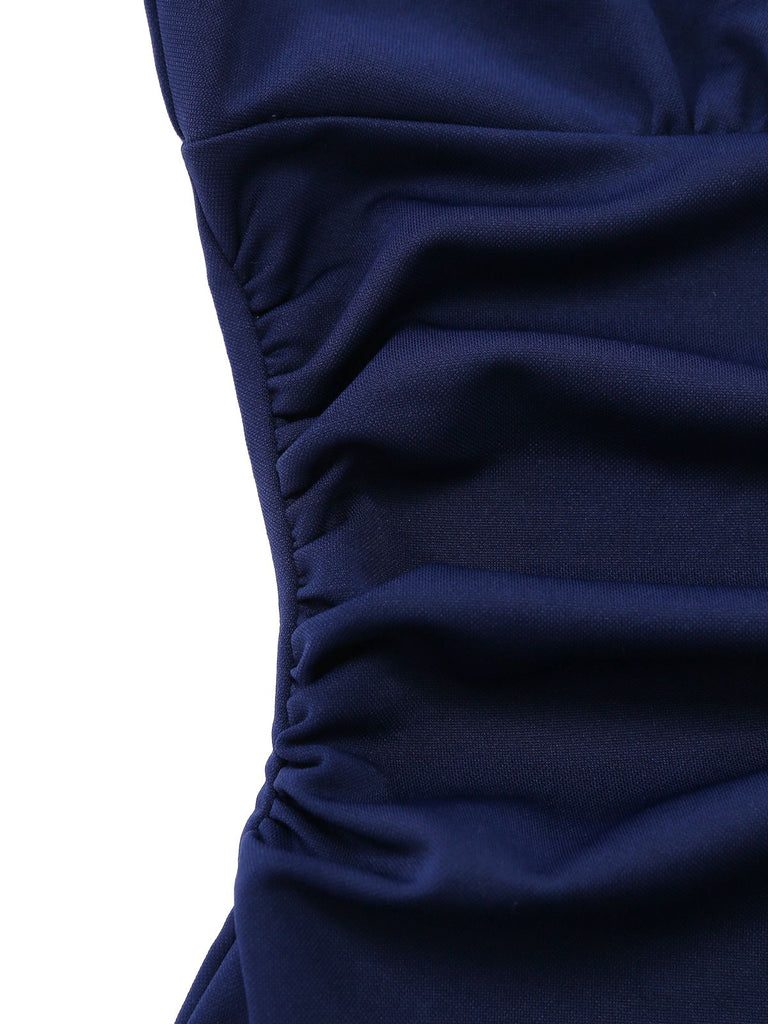 Detailed view of the horizontal side ruching and pleated fabric on the waist of the navy blue dress.