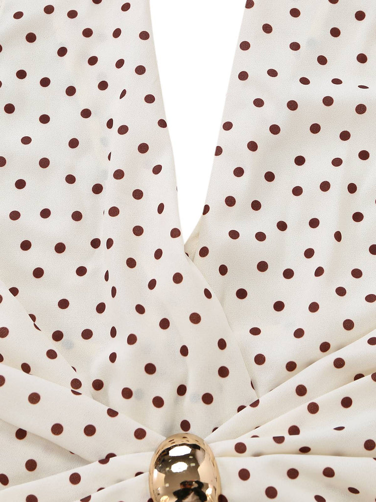 Close-up of a polka dot fabric with a gold ring on a white background